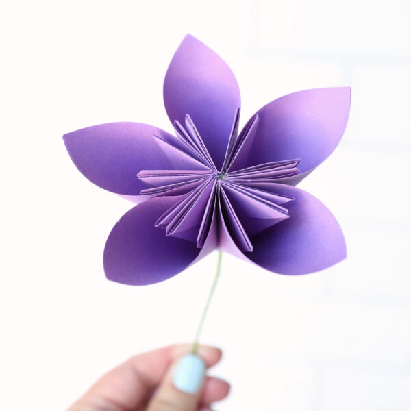 Hand holding origami flower.
