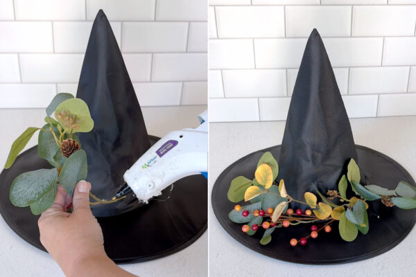 Hot gluing faux leaves and berries to a witch hat.